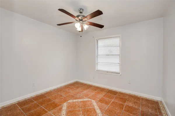 an empty room with a window and a fan