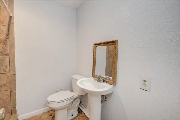 a bathroom with a sink toilet and a mirror