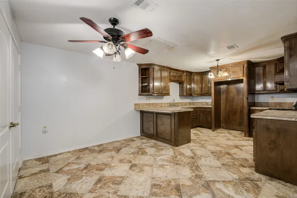 a kitchen with kitchen island granite countertop a refrigerator a sink and dishwasher