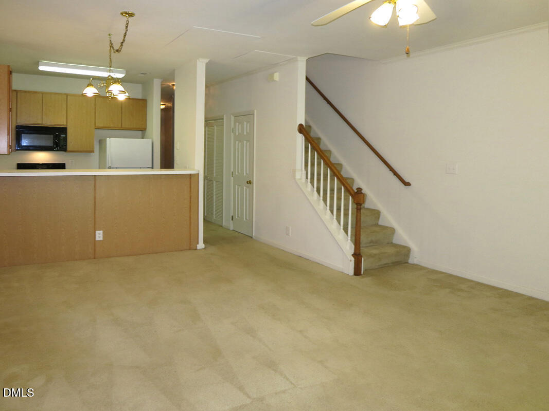 101 Rock Haven Road, Unit E502 Carrboro, NC 27510 - Photo 4 of 16 a view of an empty room with a fireplace and a chandelier fan