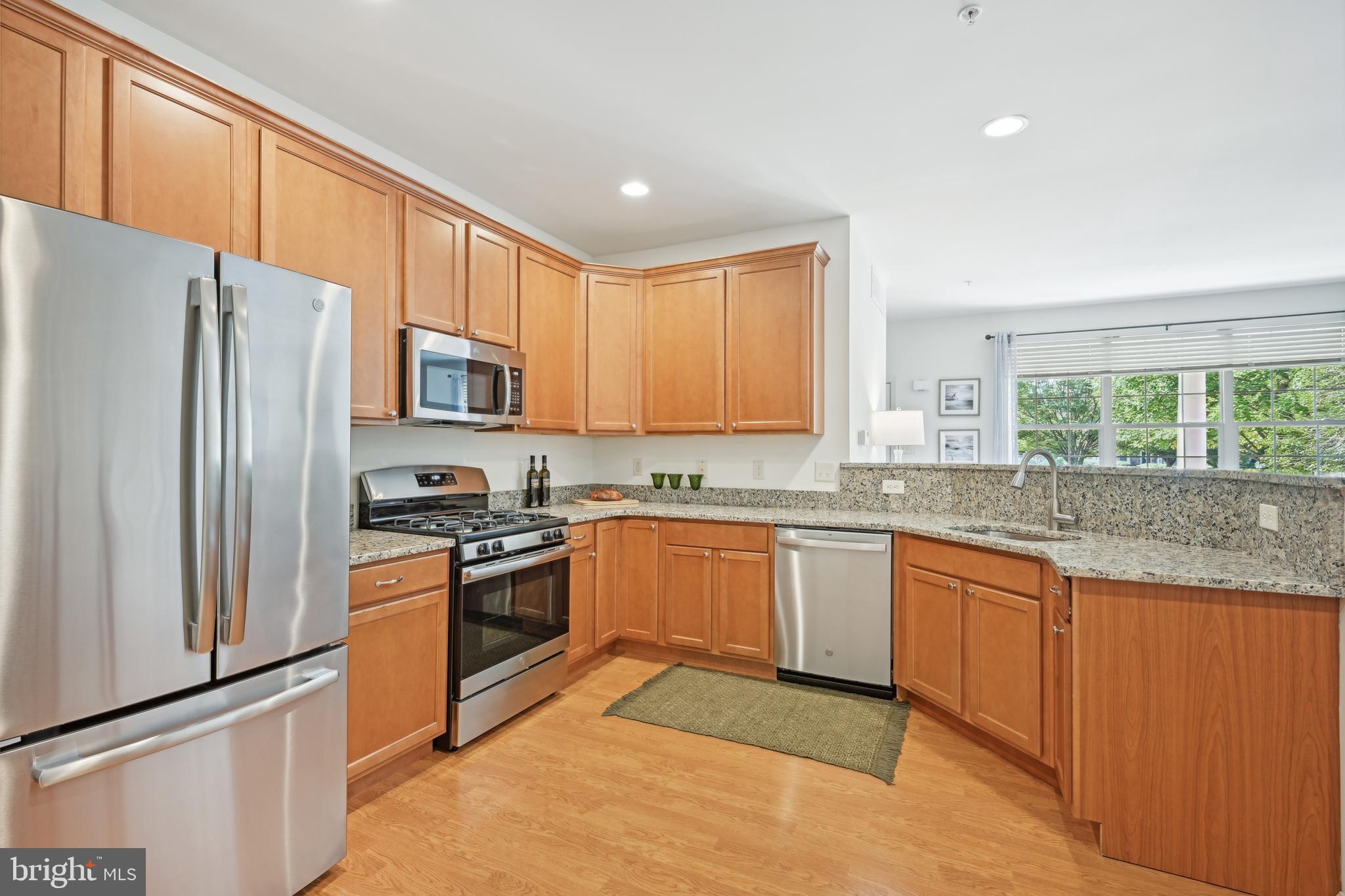 209 Blueberry Court Perkasie, PA 18944 - Photo 4 of 23 a kitchen with granite countertop stainless steel appliances a refrigerator sink and microwave
