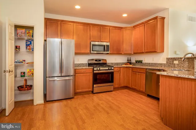 a kitchen with wooden cabinets stainless steel appliances and a window