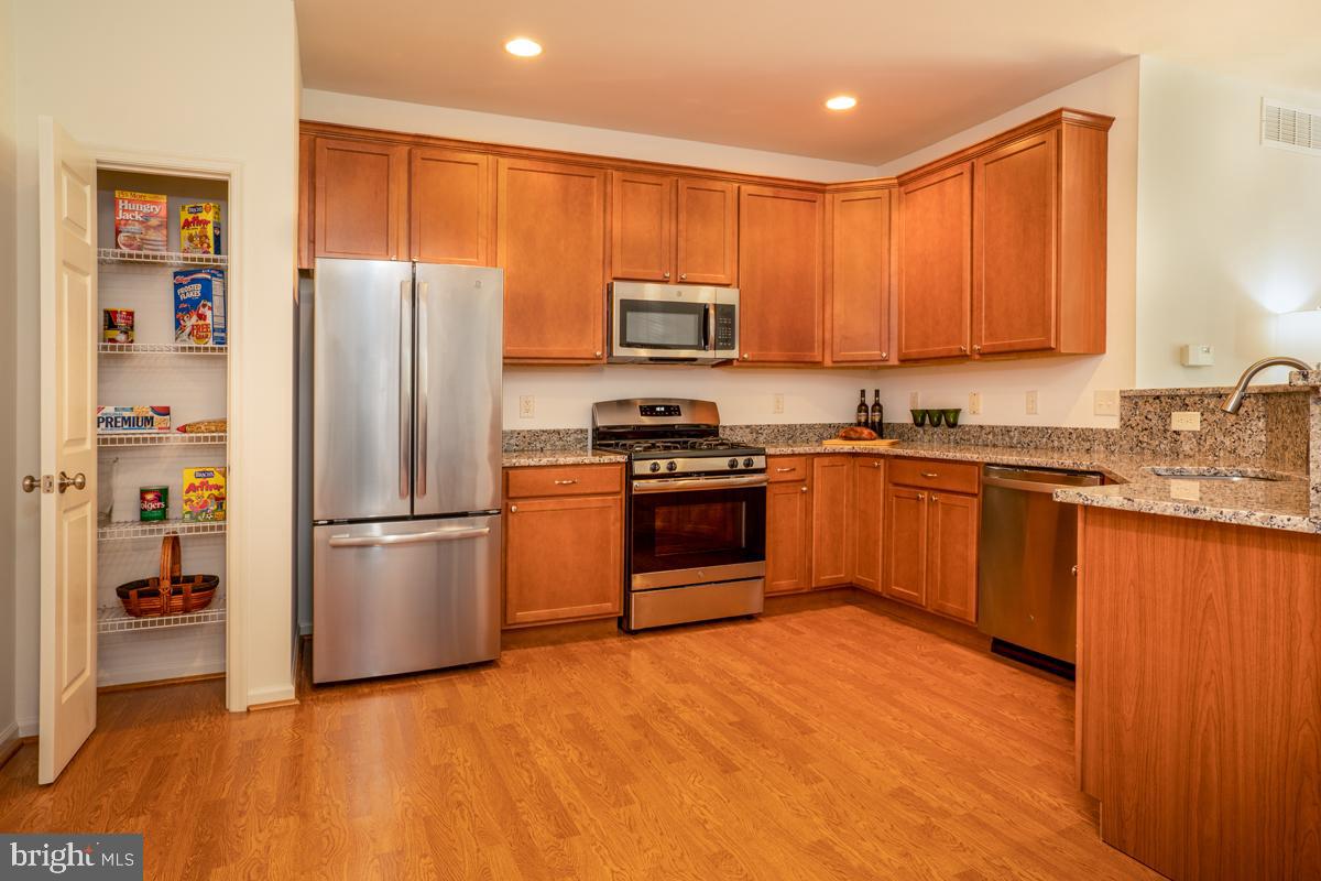 209 Blueberry Court Perkasie, PA 18944 - Photo 6 of 23 a kitchen with wooden cabinets stainless steel appliances and a window