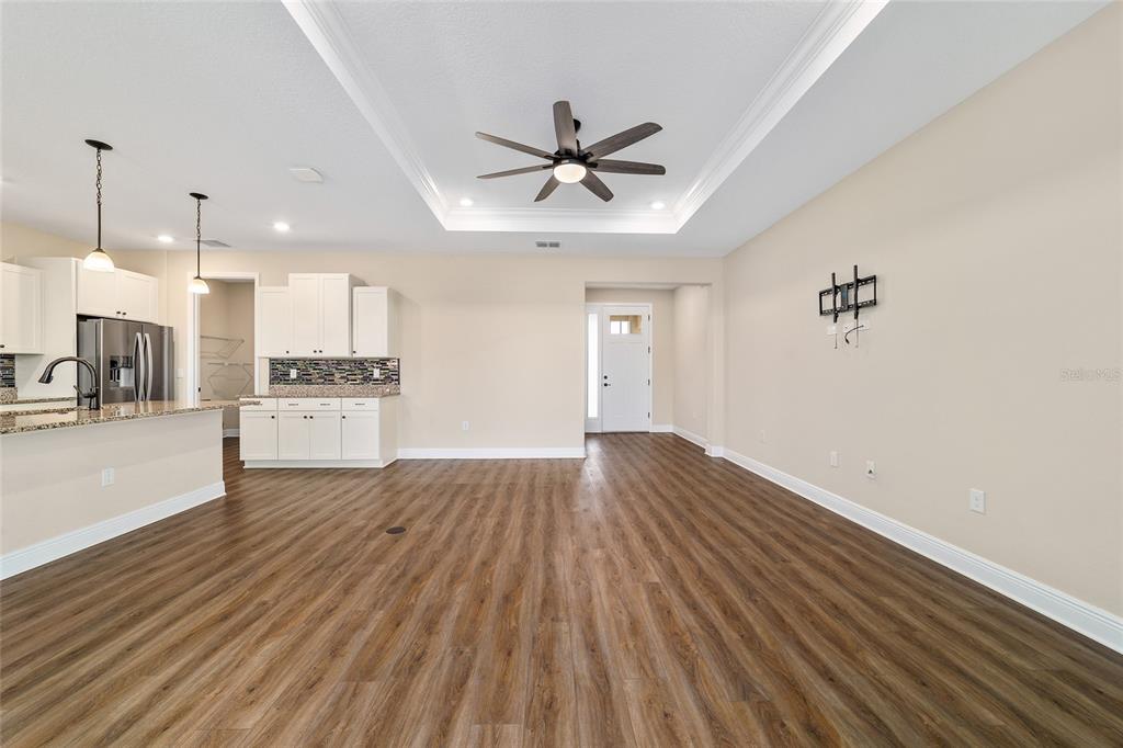 9778 Southwest 103rd Avenue Ocala, FL 34481 - Photo 15 of 57 a view of a kitchen with a stove wooden floor and a ceiling fan