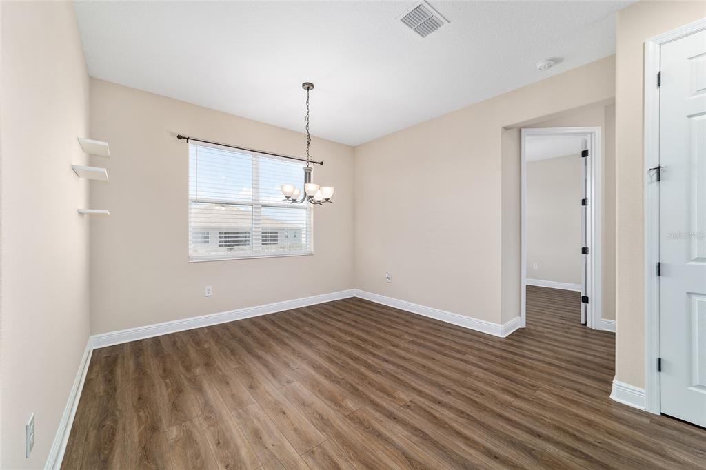 9778 Southwest 103rd Avenue Ocala, FL 34481 - Photo 20 of 57 a view of an empty room with wooden floor kitchen view and a window