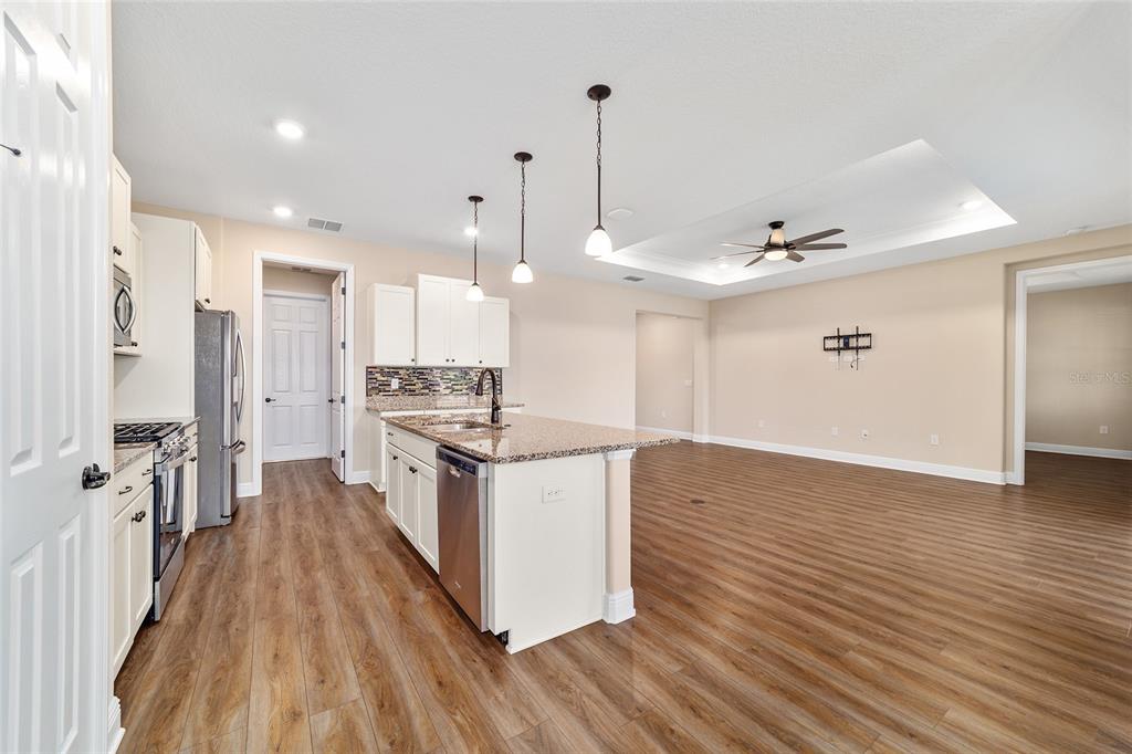 9778 Southwest 103rd Avenue Ocala, FL 34481 - Photo 22 of 57 a large kitchen with stainless steel appliances a large counter top a sink a refrigerator and a window