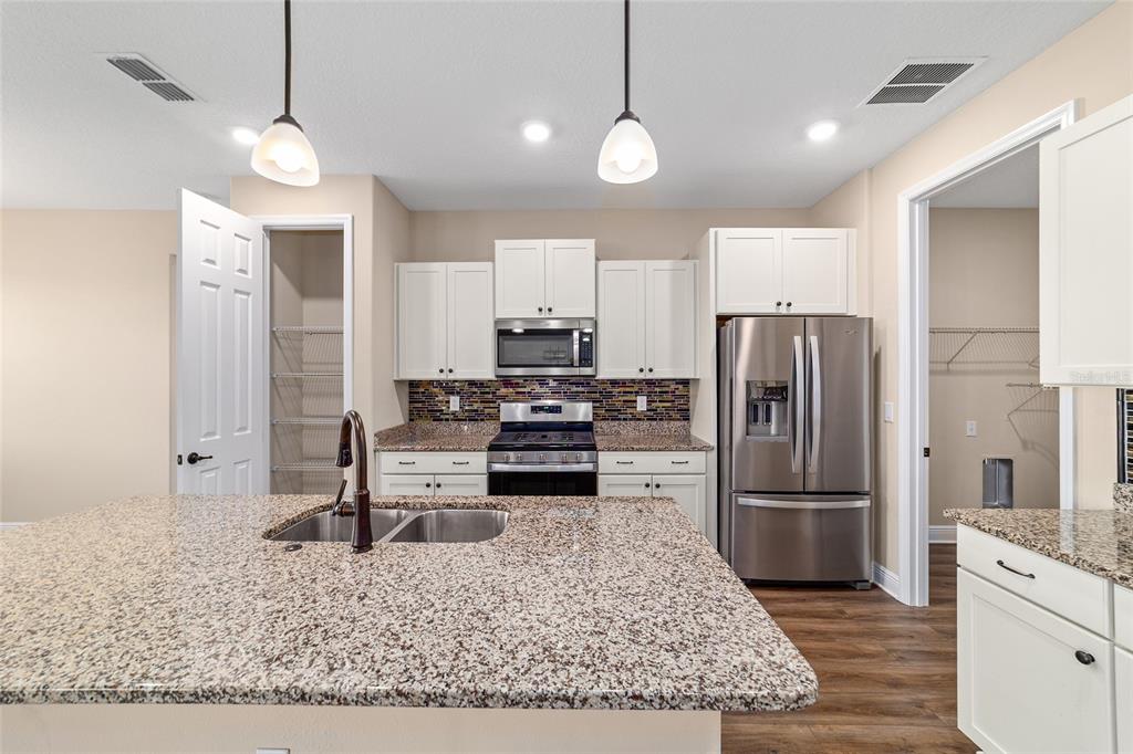 9778 Southwest 103rd Avenue Ocala, FL 34481 - Photo 25 of 57 a kitchen with a refrigerator a stove and a sink