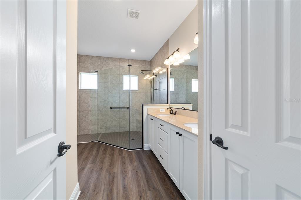 9778 Southwest 103rd Avenue Ocala, FL 34481 - Photo 34 of 57 a bathroom with a granite countertop sink a mirror and a shower