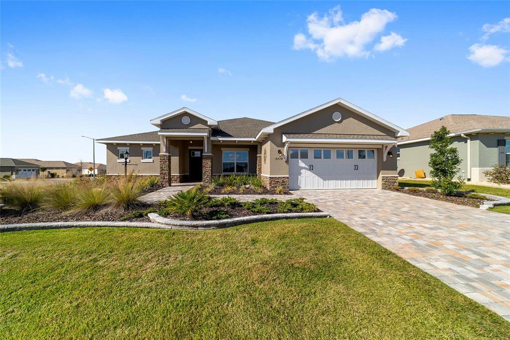 9778 Southwest 103rd Avenue Ocala, FL 34481 - Photo 4 of 57 a front view of a house with a yard table and chairs