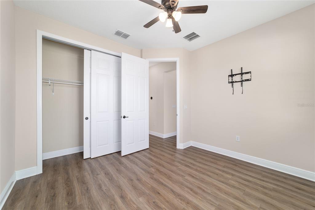 9778 Southwest 103rd Avenue Ocala, FL 34481 - Photo 43 of 57 an empty room with wooden floor and ceiling fan