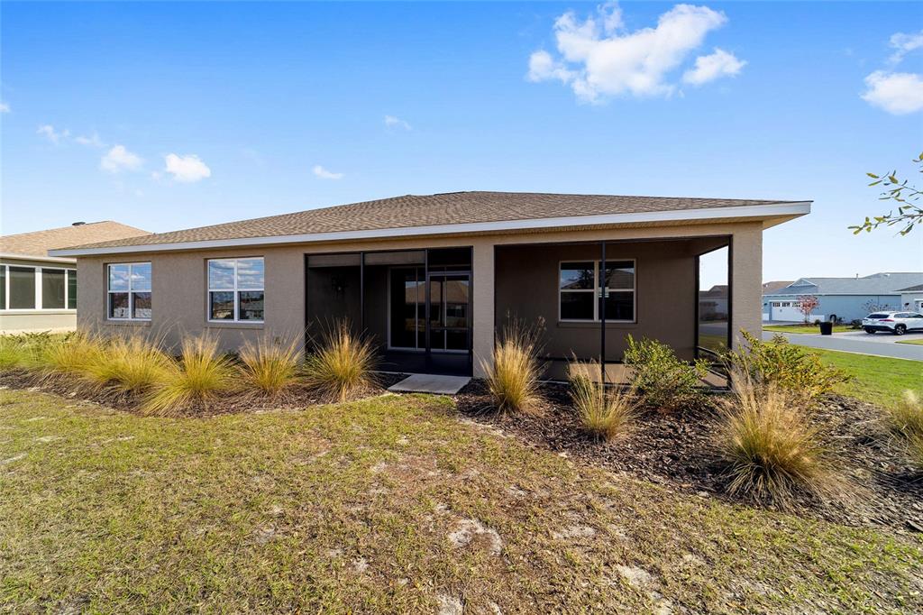 9778 Southwest 103rd Avenue Ocala, FL 34481 - Photo 53 of 57 a front view of house with yard and trees in the background