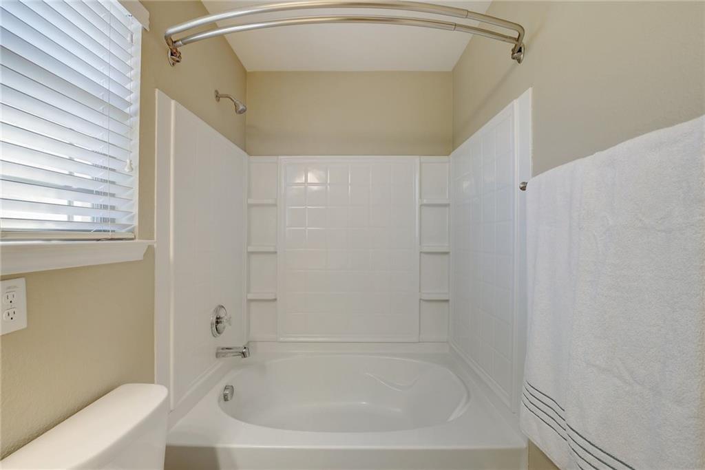 201 Edwin Kyle, TX 78640 - Photo 13 of 21 White bathtub and shower combination featuring a curved shower rod and tiled surround