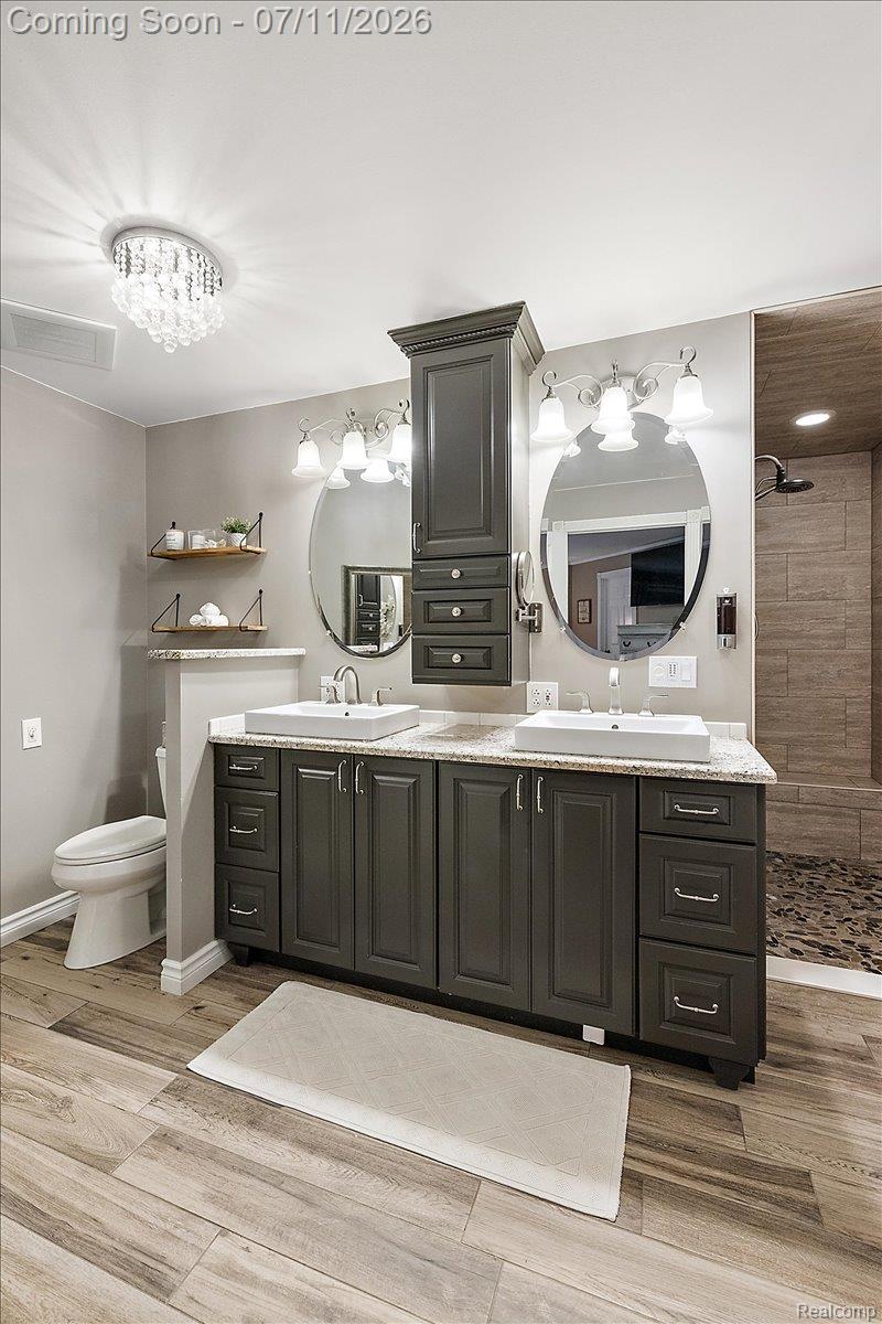 4219 Gardner Road Metamora, MI 48455 - Photo 26 of 87 Dual sink vanity with dark cabinetry, granite-style countertop, and vessel sinks