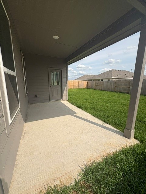 26419 Virginia Wild Rye Lane Katy, TX 77493 - Photo 6 of 31 A spacious covered patio with concrete flooring overlooks a well-maintained, fenced backyard, ideal for outdoor relaxation and privacy.