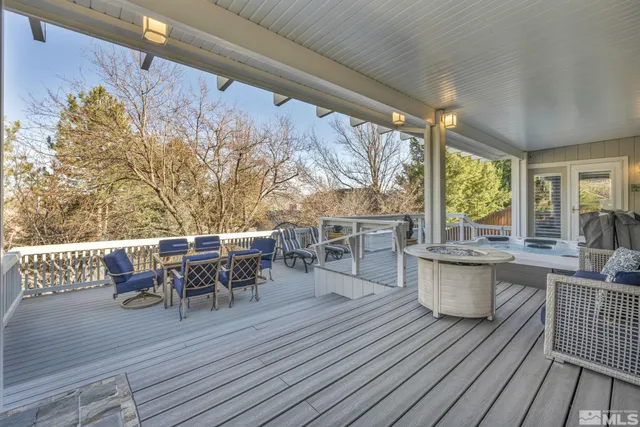a view of a roof deck with table and chairs couches with wooden floor and fence