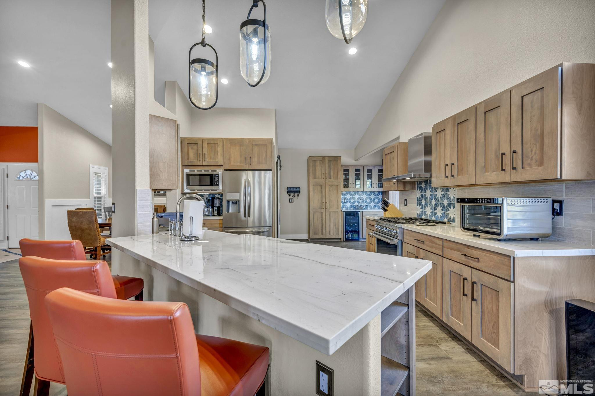 6500 Brookview Circle Reno, NV 89519 - Photo 6 of 24 a large kitchen with stainless steel appliances granite countertop a table chairs in it and wooden floors