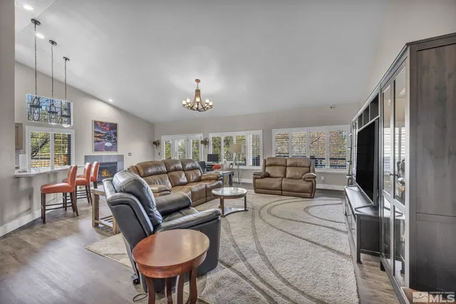 a living room with furniture a chandelier a rug and a window