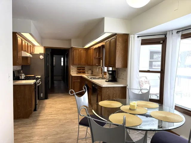 a kitchen with a table chairs stove and refrigerator