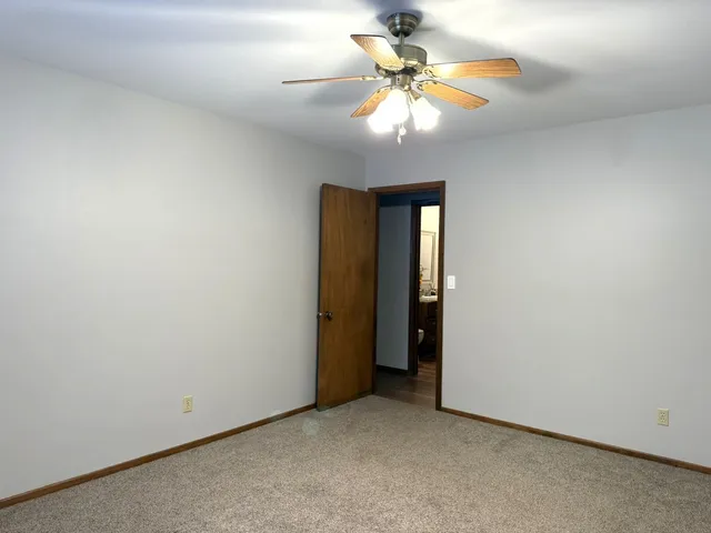 an empty room with closet and a chandelier fan