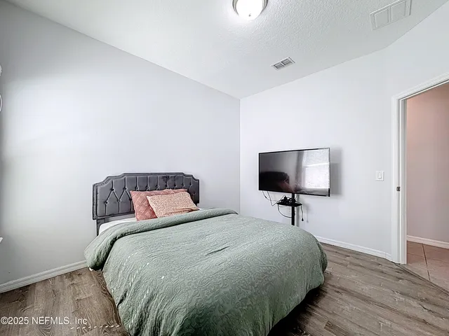 a bedroom with a bed and a flat screen tv