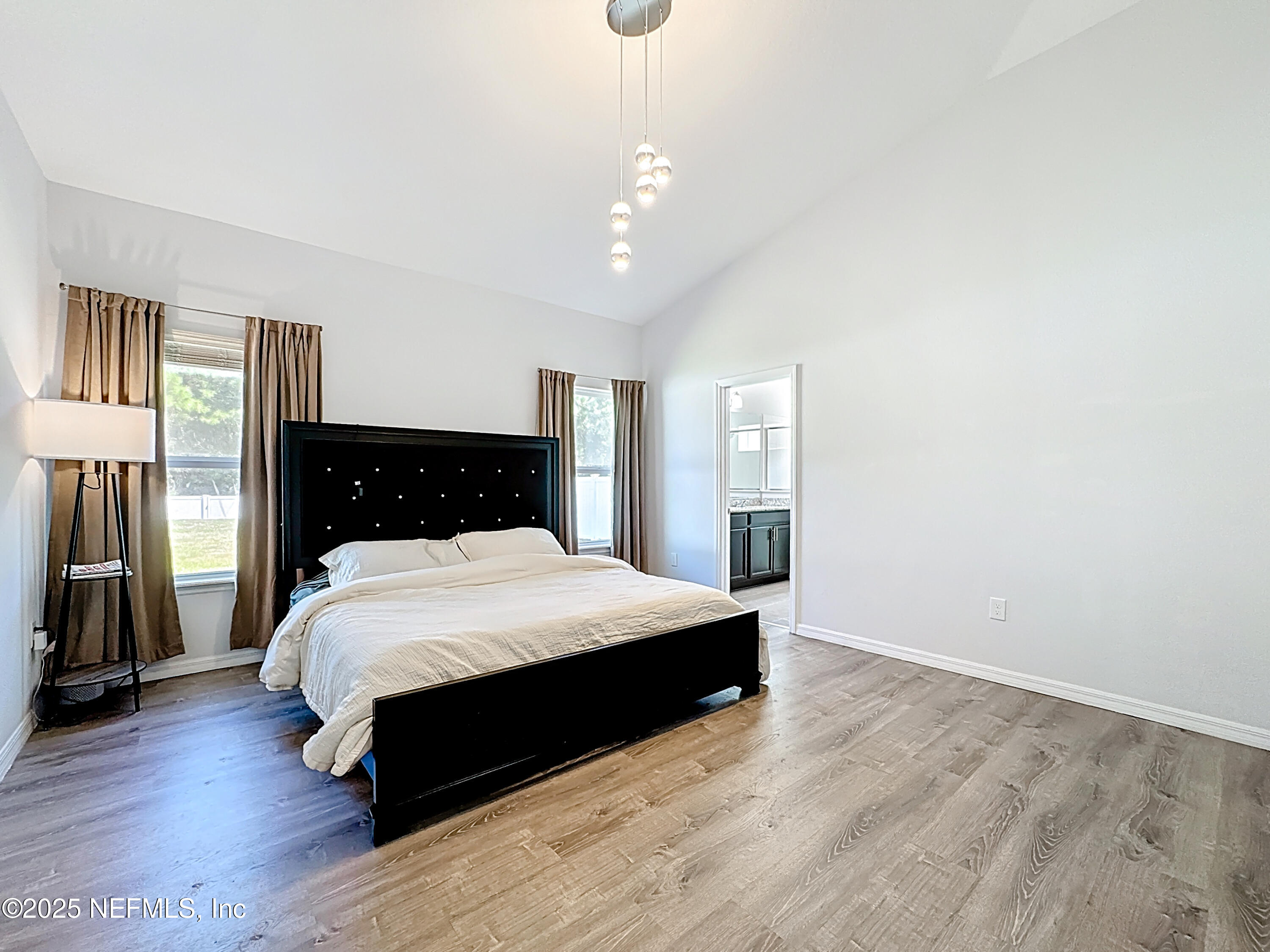 3473 Middlebrook Place St. Cloud, FL 34773 - Photo 18 of 32 a spacious bedroom with a bed and a dresser with wooden floor