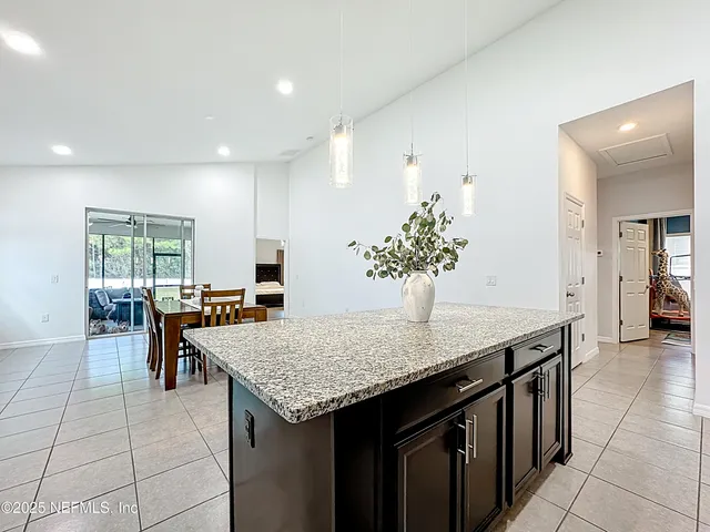 a kitchen with granite countertop kitchen island a sink table and chairs