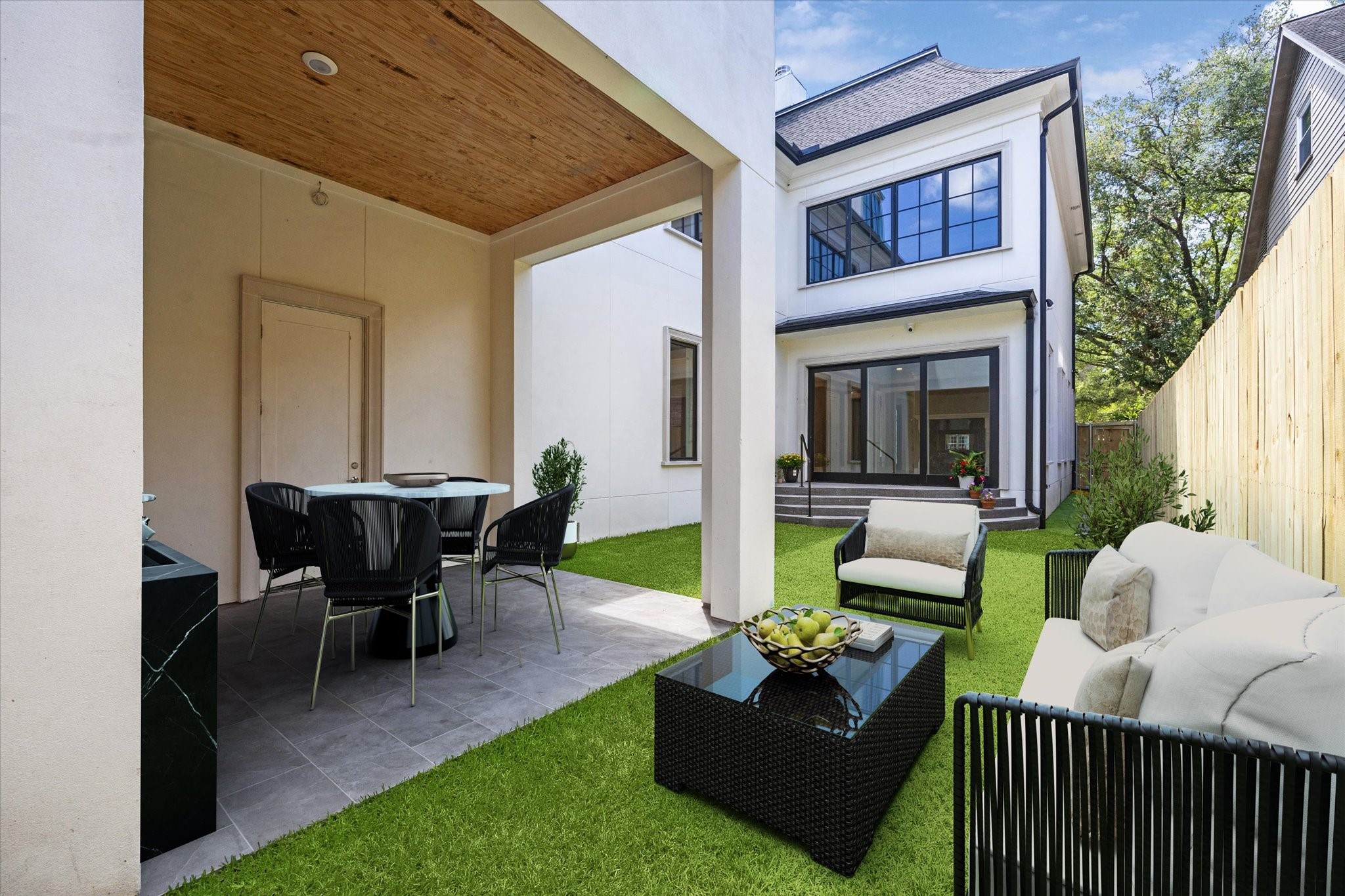 2216 Tangley Street Houston, TX 77005 - Photo 23 of 44 Relaxing or entertaining in this inviting backyard with a cozy outdoor seating area, covered patio for dining, and vibrant green grass. The covered area is ready for you to install your own kitchen equipment or if you want, possibly think even a small pool for those sunny summer days! This photo has been virtually staged.