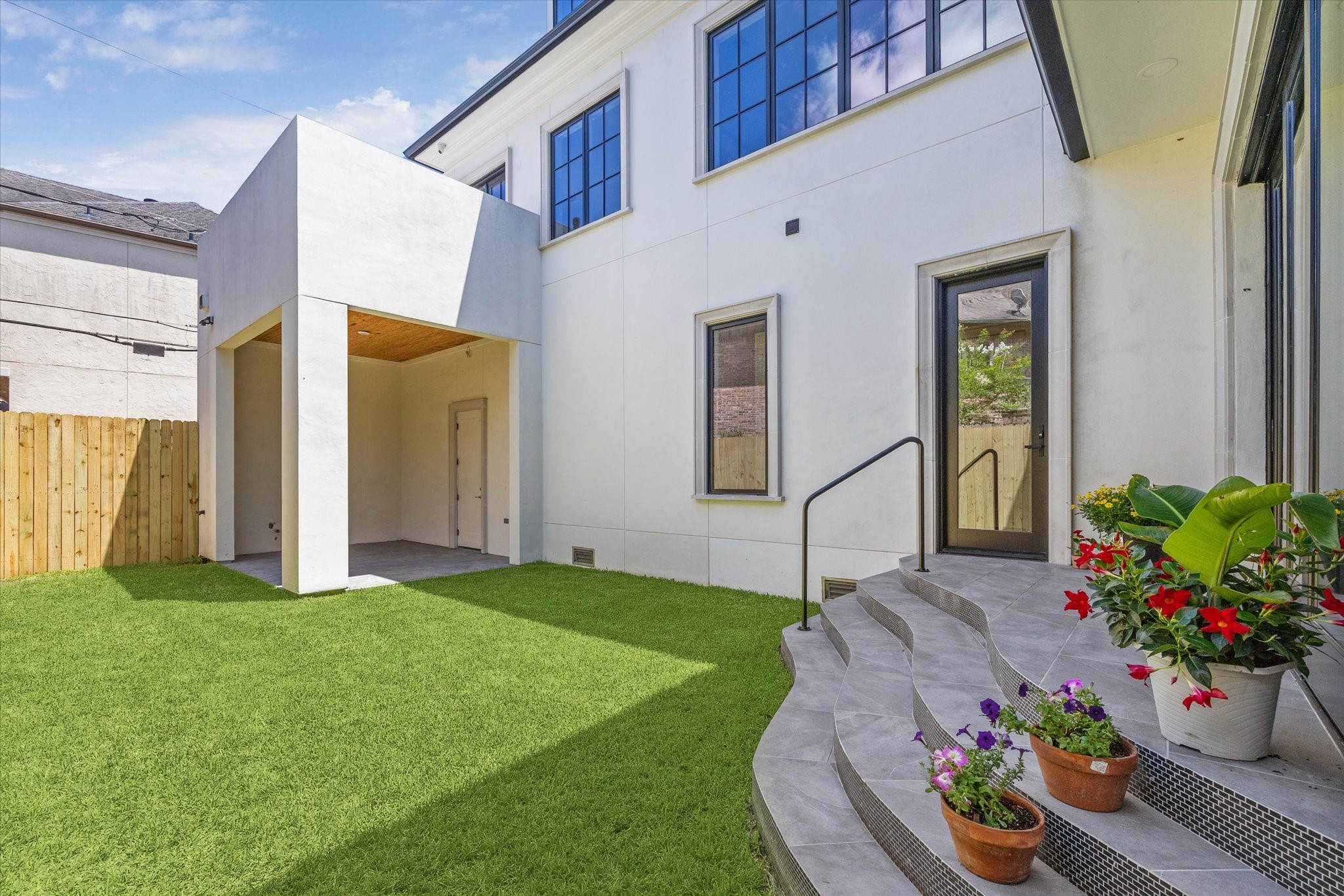 2216 Tangley Street Houston, TX 77005 - Photo 24 of 44 Such an attractive entrance from the family room/den to the outdoor space--down these steps and onto the grassy area and them looking to the covered patio. That is the 2nd floor balcony located above the covered patio.