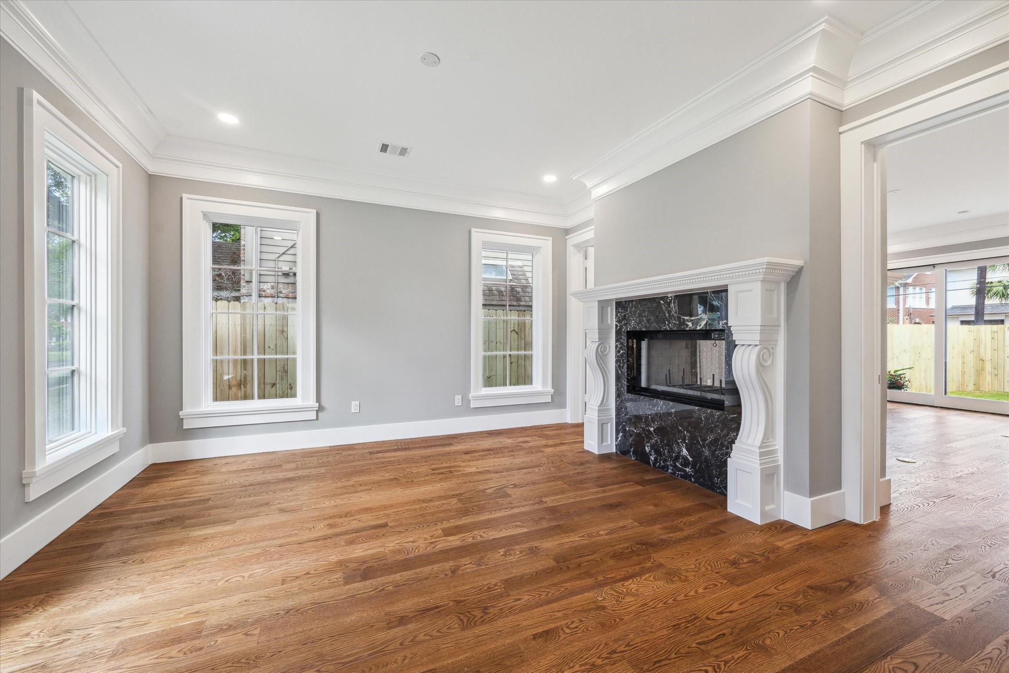2216 Tangley Street Houston, TX 77005 - Photo 29 of 44 A view of the living room/study that features the outstanding double sided fireplace flanked by doors that can be closed for privacy. Lovely large windows provide light on 2 walls.
