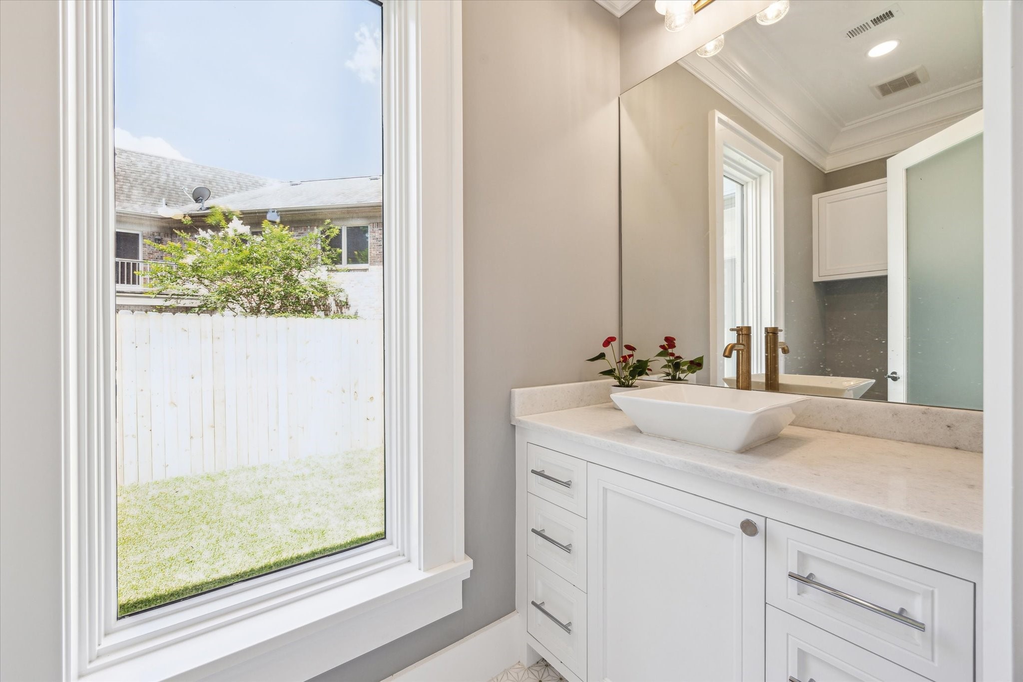 2216 Tangley Street Houston, TX 77005 - Photo 8 of 44 This first floor powder room features a modern vanity with a sleek vessel sink and stylish gold fixtures.
