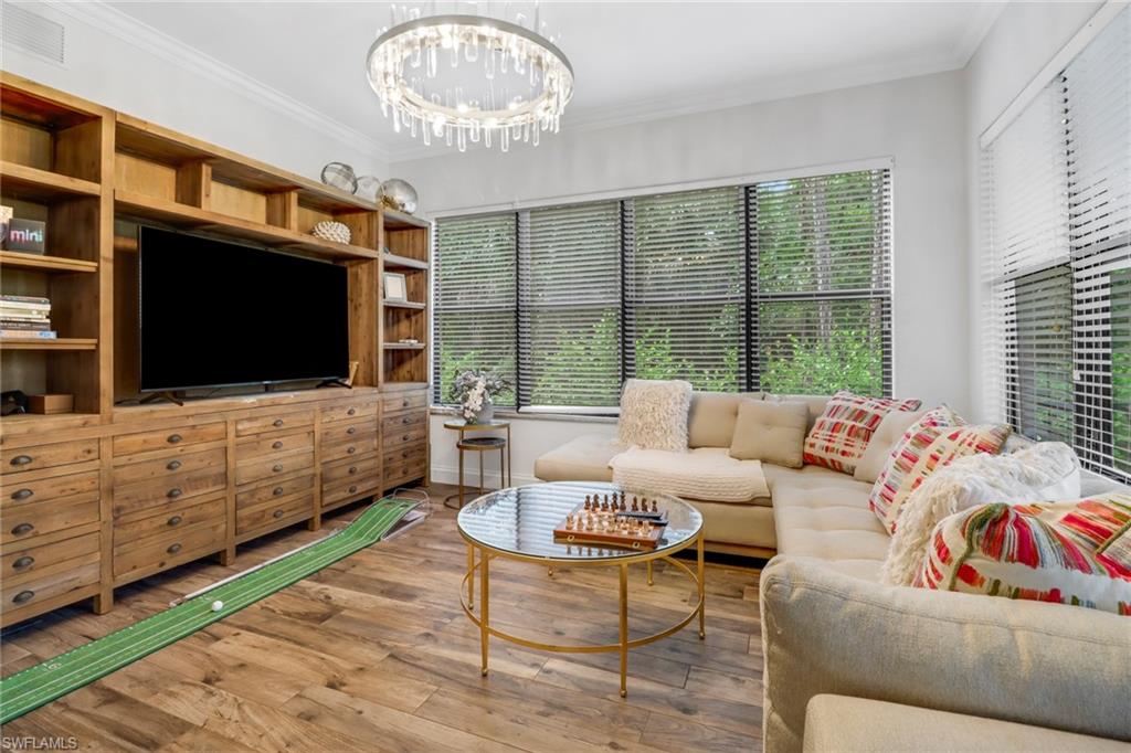a living room with furniture a flat screen tv and a floor to ceiling window