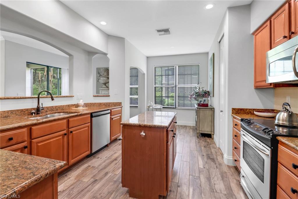 1326 Corso Palermo Court, Unit 3 Naples, FL 34105 - Photo 11 of 33 a large kitchen with stainless steel appliances granite countertop a lot of counter space and wooden floors