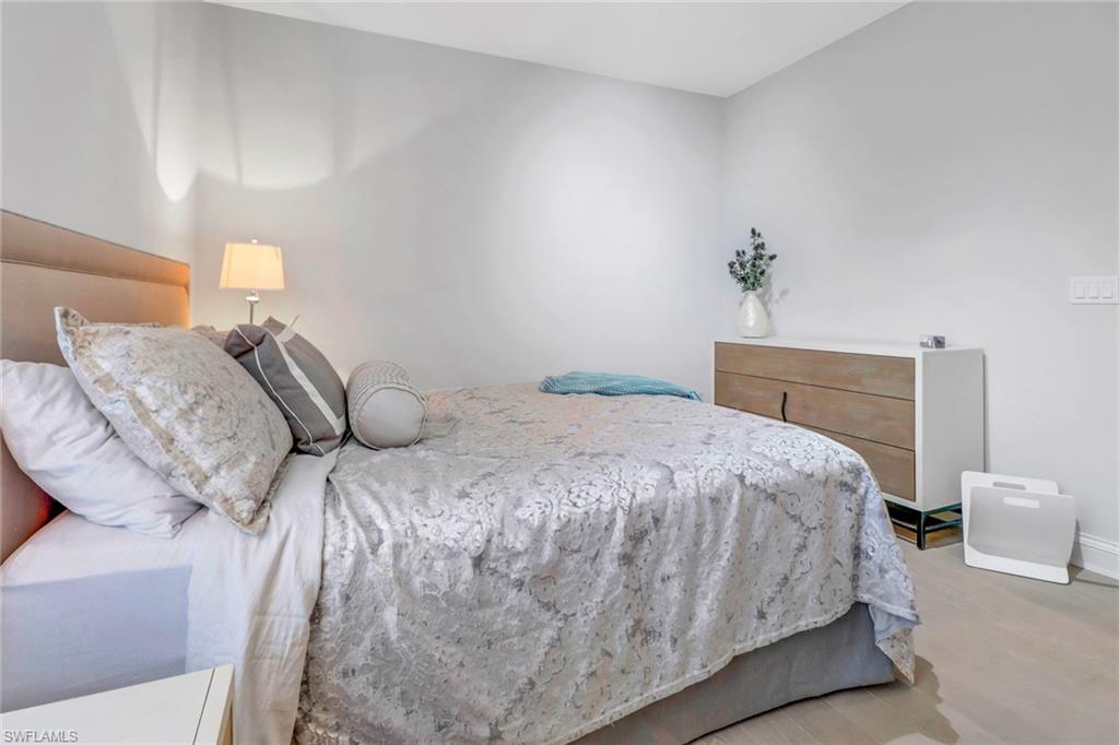 1326 Corso Palermo Court, Unit 3 Naples, FL 34105 - Photo 18 of 33 a bedroom with a bed and a potted plant