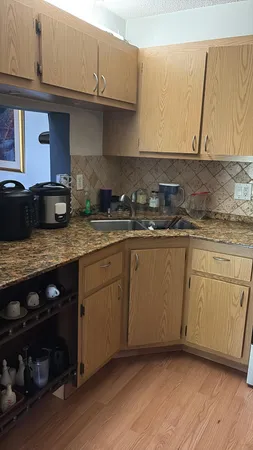 a kitchen with stainless steel appliances granite countertop a sink a stove and wooden cabinets