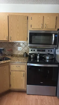 a kitchen with granite countertop a stove and a microwave