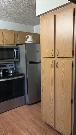 a kitchen with a refrigerator and a stove top oven