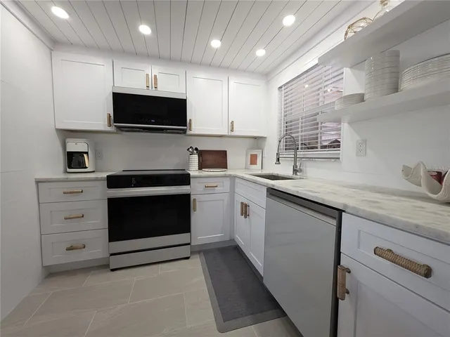 a kitchen with a sink stainless steel appliances and cabinets