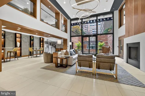 a living room with furniture a fireplace and large windows