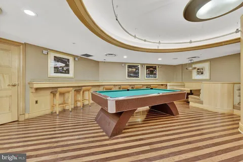 a room with wooden floor table and chairs