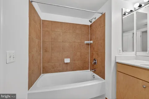 a bathroom with a tub shower and a sink