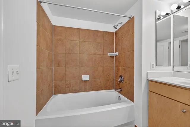 a bathroom with a tub shower and a sink