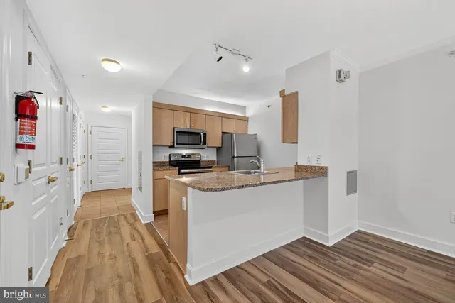 a kitchen with stainless steel appliances a refrigerator sink and microwave
