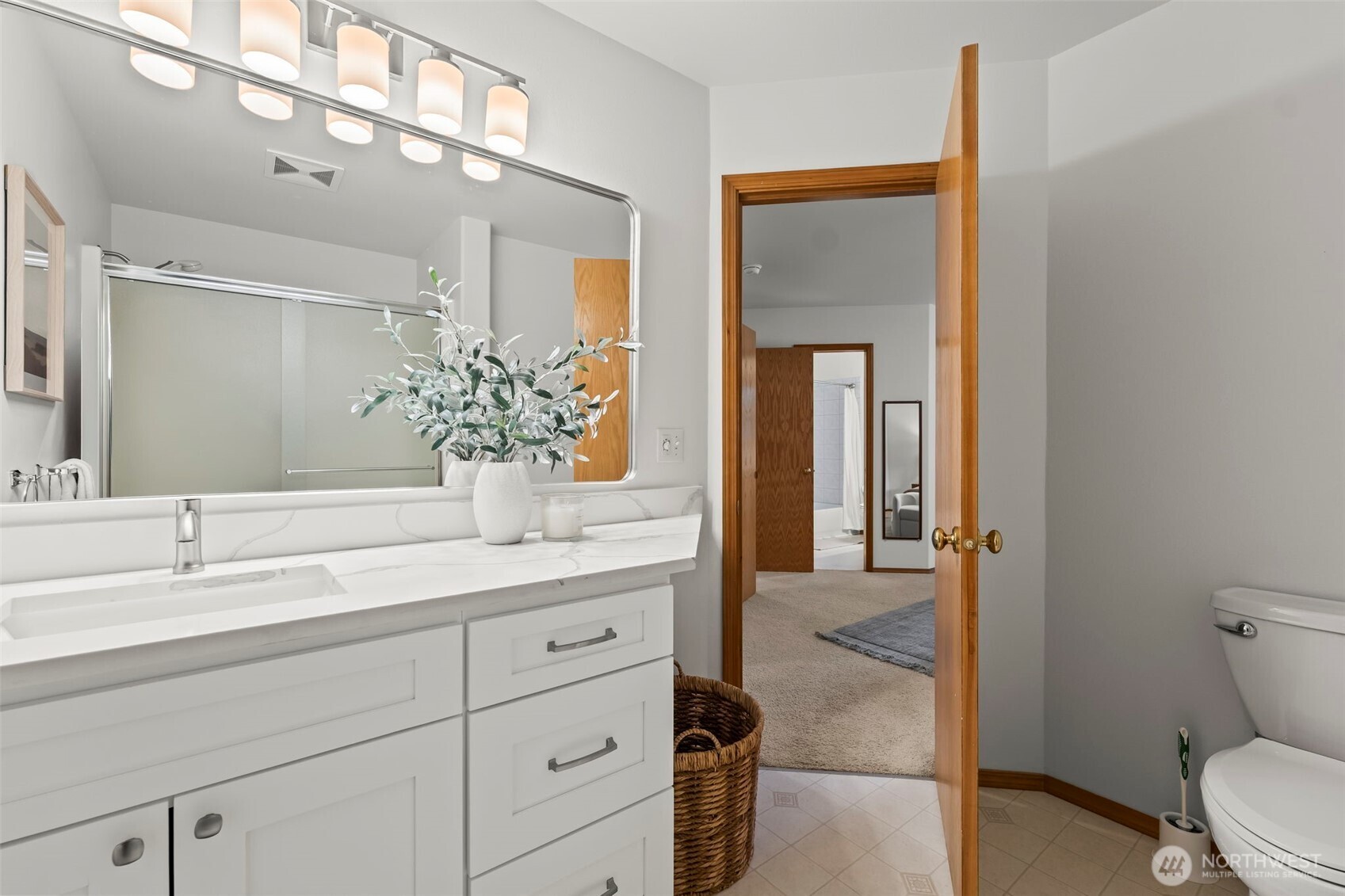 5203 53rd Street West University Place, WA 98467 - Photo 17 of 24 a bathroom with a granite countertop sink a toilet and a mirror