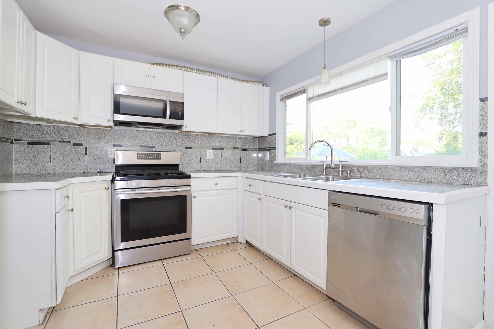 427 Mallview Lane, Unit 427 Bolingbrook, IL 60440 - Photo 5 of 16 a kitchen with white cabinets appliances a sink and a window