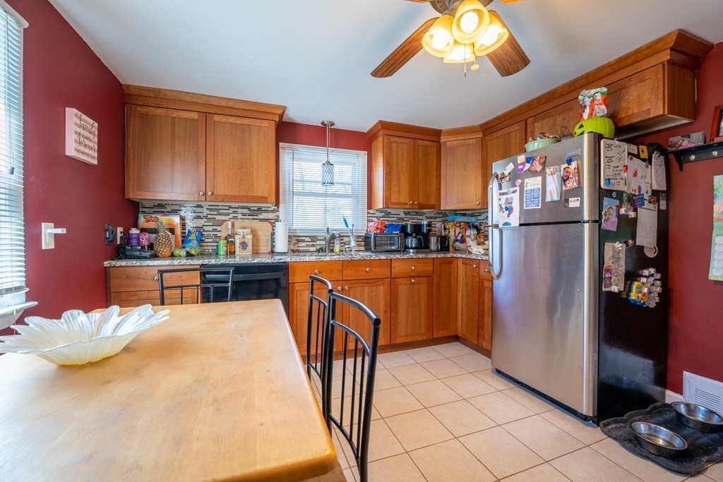 286 Redlands Street Springfield, MA 01104 - Photo 8 of 27 a kitchen with stainless steel appliances kitchen island granite countertop a refrigerator a stove and a dining table with painted walls