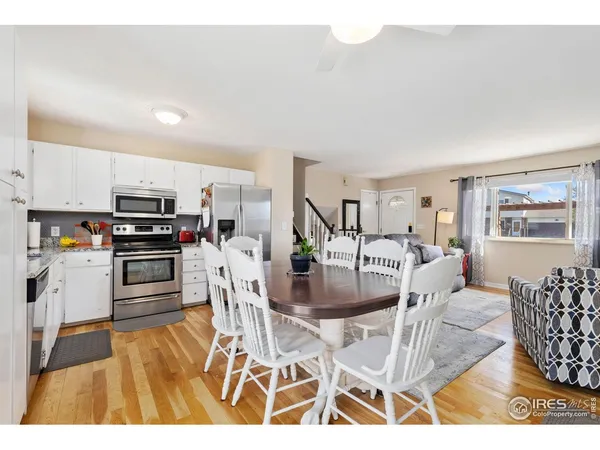 a kitchen with stainless steel appliances kitchen island granite countertop a dining table chairs and granite counter tops