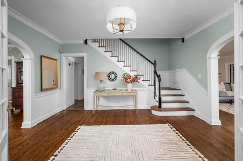 a view of entryway and hall with wooden floor