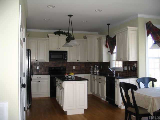 4517 Deer Stream Lane Raleigh, NC 27603 - Photo 3 of 11 a kitchen with kitchen island granite countertop a sink stainless steel appliances and cabinets