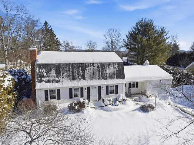 a view of a white house with a yard covered in snow