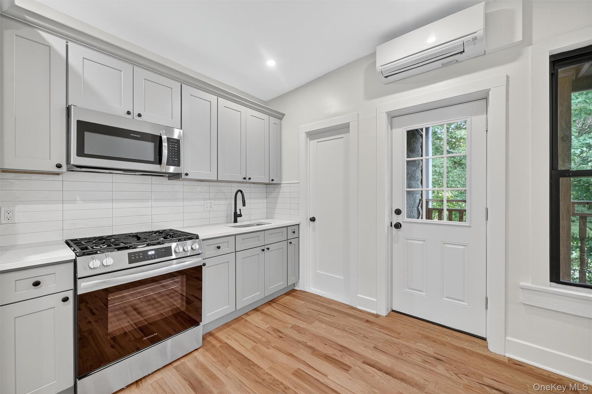 79 Main Street, Unit 2E Ossining, NY 10562 - Photo 10 of 20 a kitchen with granite countertop wooden cabinets stove top oven and sink